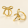 Gold bow napkin rings on cream background